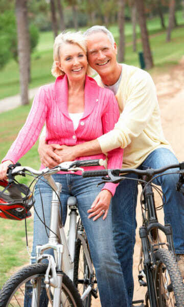 Older couple on mountain bikes pose for a photo - Blocked Leg Arteries Page Image